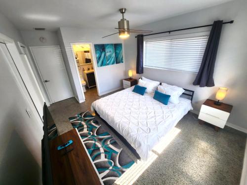 una camera da letto con un letto bianco e una finestra di Paradise Awaits! Beach, King Bed, Private Yard & Workspace a Deerfield Beach