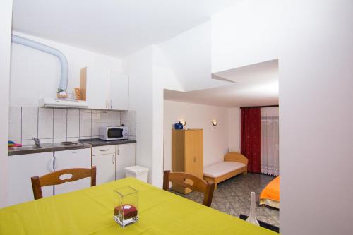 a kitchen and dining room with a yellow table at Apartmani Žužić in Krk