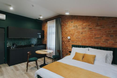 a bedroom with a bed and a brick wall at Apartamenty BIBLIO in Łódź