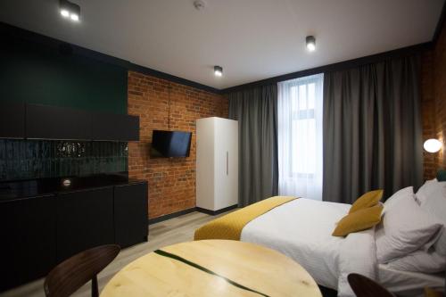 a hotel room with a bed and a table at Apartamenty BIBLIO in Łódź