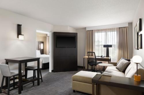 Habitación de hotel con sofá y sala de estar. en Residence Inn by Marriott Madison West/Middleton, en Middleton