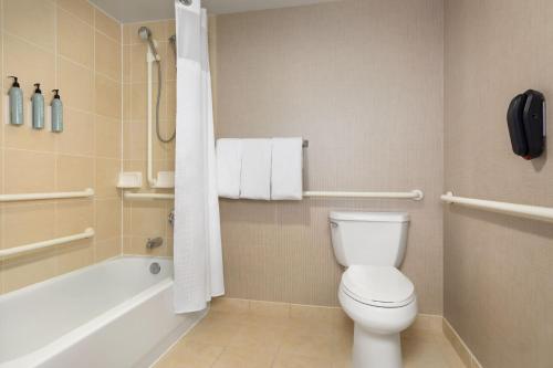 a bathroom with a toilet and a tub and a sink at Residence Inn by Marriott Madison West/Middleton in Middleton
