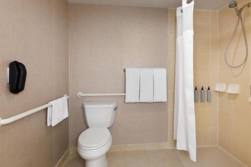 a bathroom with a toilet and a shower with towels at Residence Inn by Marriott Madison West/Middleton in Middleton