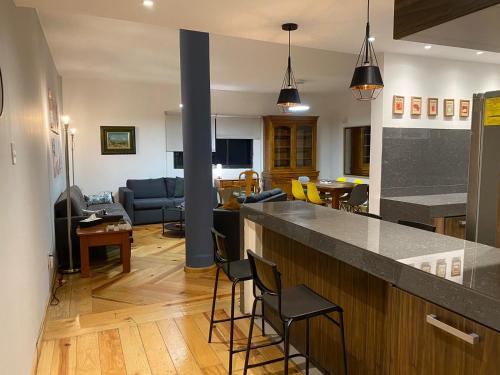eine Küche und ein Wohnzimmer mit einer Theke und Stühlen in der Unterkunft Corazón de condesa in Mexiko-Stadt