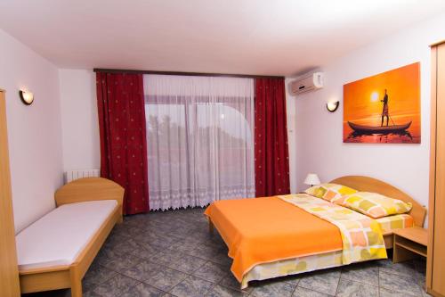 a hotel room with a bed and a window at Apartmani Žužić in Krk