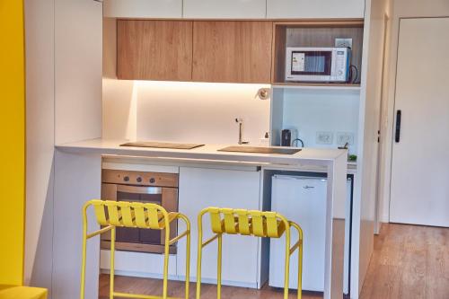 a kitchen with two yellow chairs and a counter at Babel Arcos in Buenos Aires