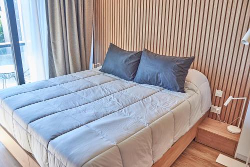 a large bed with blue pillows in a bedroom at Babel Arcos in Buenos Aires