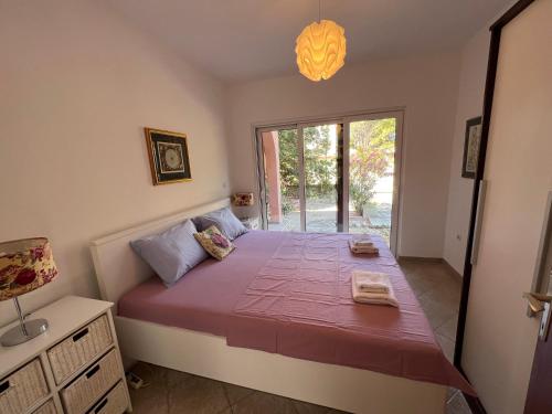 een slaapkamer met een groot bed met een raam bij Šimuni holiday home by Pag tours in Šimuni