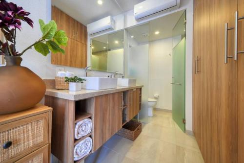 a bathroom with a sink and a toilet and a mirror at Cozy 1Br Apt - Pool - GYM in Bucerías