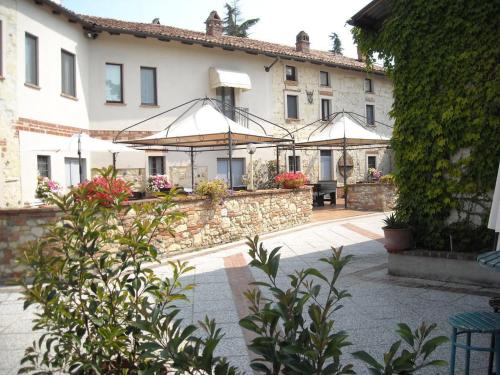 ein großes Gebäude mit Sonnenschirmen im Innenhof in der Unterkunft Albergotto Natalina in Grazzano Badoglio