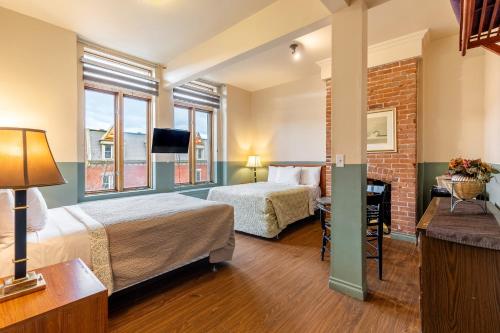 a hotel room with two beds and a window at Hotel Auberge Manoir Ville Marie in Montreal