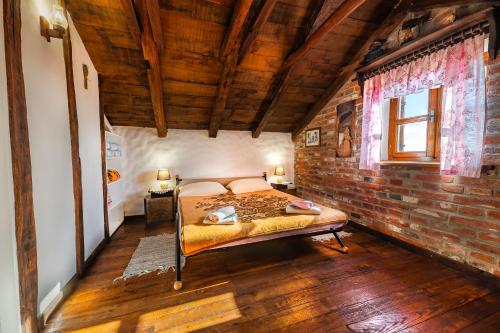 ein Schlafzimmer mit einem Bett und einer Ziegelwand in der Unterkunft Kuća sreće Veronika in Nova Gradiška