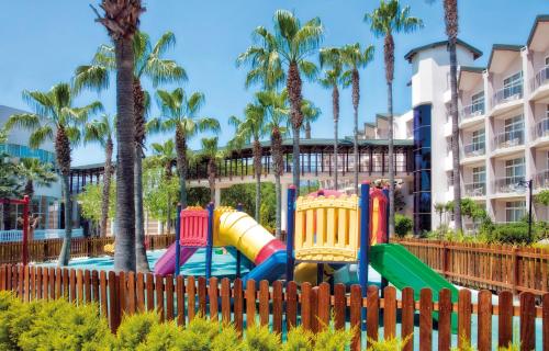 einen Spielplatz in einem Resort mit Palmen in der Unterkunft Dobedan World Palace Hotel ''Ex Brand Alva Donna World Palace '' in Kemer