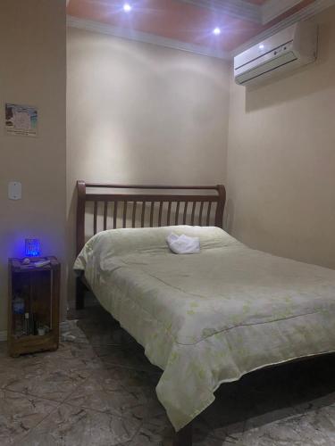 1 dormitorio con cama y mesita de noche con aperitivo en Los gringos del caribe en Saquarema