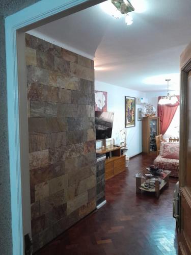 sala de estar con pared de piedra en Departamento Loló en Mendoza