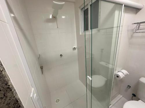 een douche met een glazen deur in de badkamer bij Spazzio Di Roma - Apartamentos para Temporada in Caldas Novas