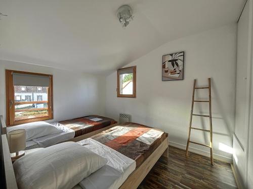 ル・クロトワにあるLes Rêves du Crotoyのベッド2台付きの部屋、壁にははしごが備わります。
