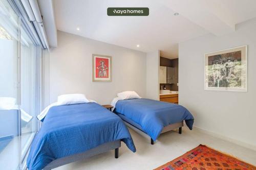 2 camas en un dormitorio con edredones azules en New 2BR Condo Perfect for Long Stays w/ Balcony, en Ciudad de México