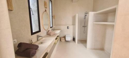La salle de bains blanche est pourvue d'une baignoire et d'un lavabo. dans l'établissement Lalla Essaouira, Villa Najma avec piscine pour 10 personnes, à Essaouira