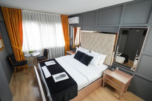 Lukka Suit Hotel في إسطنبول: غرفة فندقية بسرير كبير وطاولة