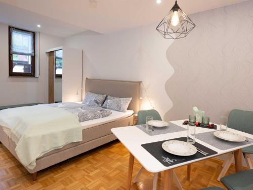 LangenthalにあるFerienapartment Am Gaulsbachのベッドとテーブルと椅子のある寝室