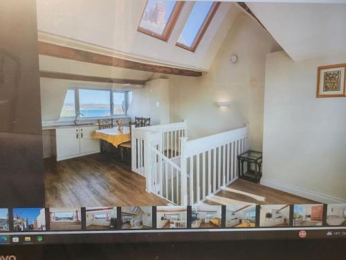 a kitchen and dining room with a staircase in a house at Beach & Harbour View House in Weymouth
