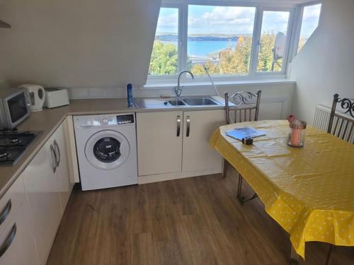 a kitchen with a sink and a washing machine at Beach & Harbour View House in Weymouth