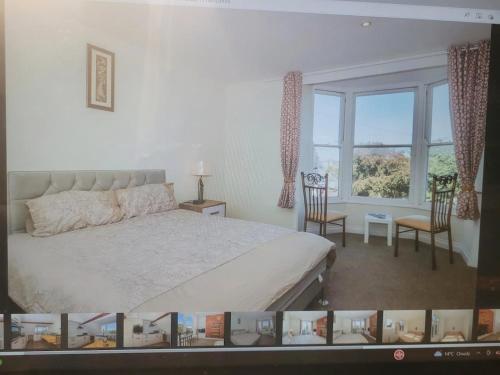 a bedroom with a bed and two chairs and a window at Beach & Harbour View House in Weymouth