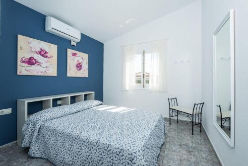 a bedroom with a bed and a blue wall at Villa Patri in Cala'n Porter