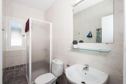 a bathroom with a toilet and a sink and a mirror at Villa Patri in Cala'n Porter