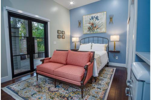 a bedroom with a bed and a couch and a chair at Exquisite Studio Guesthouse Near Downtowns Core in San Antonio