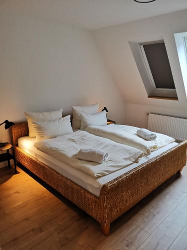 a large bed with white sheets and pillows in a room at Ferienbauernhof Ennenhof in Schneverdingen