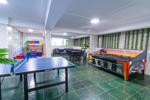 a living room with a ping pong table and a table at Luz Hotel by Castelo Itaipava in Foz do Iguaçu