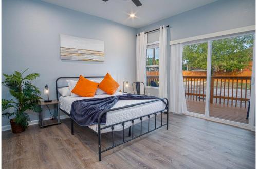 a bedroom with a bed with orange pillows and a balcony at Downtown Dream Home Spacious 4BR2BA Sleeps 12 in San Antonio