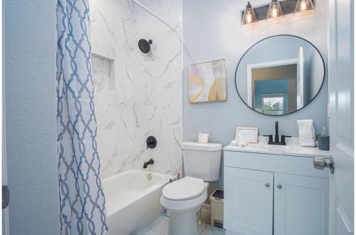 a bathroom with a toilet and a sink and a mirror at Downtown Dream Home Spacious 4BR2BA Sleeps 12 in San Antonio