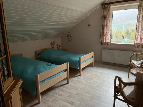 1 dormitorio con 2 camas y ventana en Unter den Wolken, en Winterberg