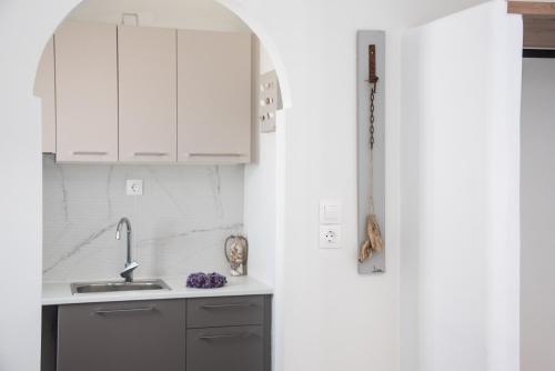 una cucina con mobili bianchi e un lavandino di Navi B3 Brand New studio in Naousa a Naoussa