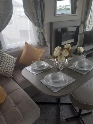 uma sala de estar com uma mesa e um sofá em Littlesea Haven Weymouth em Weymouth
