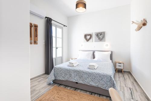 a white bedroom with a bed and a window at Navi B3 Brand New studio in Naousa in Naousa