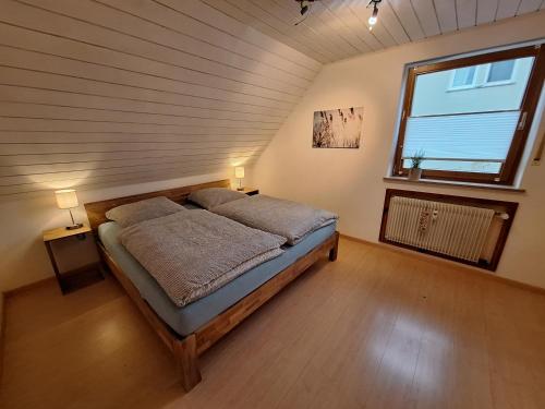 - une chambre avec un lit dans une pièce dotée d'une fenêtre dans l'établissement Ferienwohnung in Schnaid, à Hallerndorf