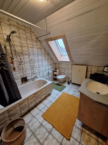 La salle de bains est pourvue d'une baignoire, d'un lavabo et de toilettes. dans l'établissement Ferienwohnung in Schnaid, à Hallerndorf