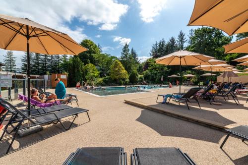 a group of people sitting in lawn chairs next to a pool at Camping LA SERRE in Aigues-Vives