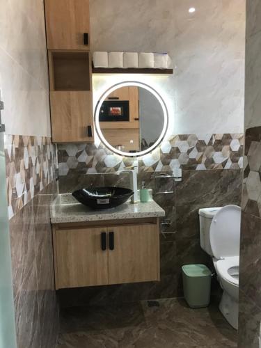 a bathroom with a sink and a mirror and a toilet at S.K PLAZA in East Legon