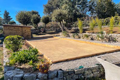 - un terrain de basket dans un jardin avec un mur en pierre dans l'établissement Villa 6 Guests with Pool - Peymeinade near Cannes, à Peymeinade