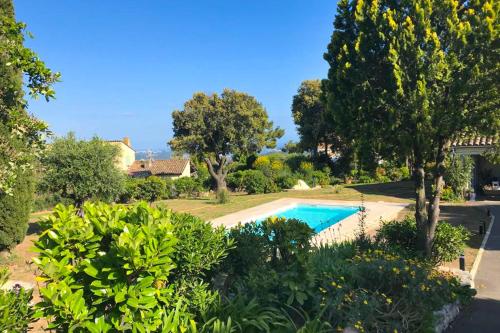 a swimming pool in a yard with trees and bushes at Villa with swimming pool for 6 people in Peymeinade near Cannes in Peymeinade