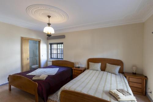 a bedroom with two beds and a window at Casa do Patrão - Quartos in Sabugueiro