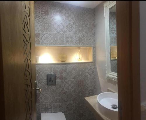 a bathroom with a sink and a toilet and a mirror at home & room center of rabat in Rabat