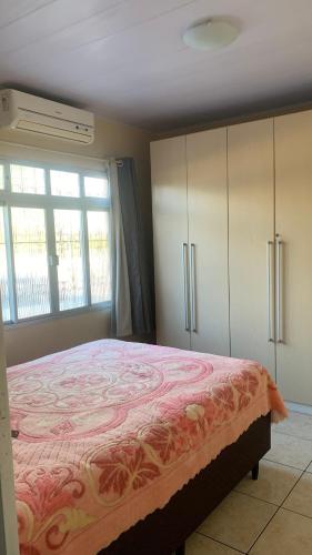 a bedroom with a large bed and a window at Casa - Florianópolis, ponta das canas in Florianópolis