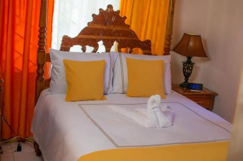 a bedroom with a bed with a white towel on it at Windbreak Villa in Buff Bay