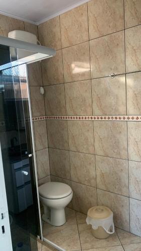 a bathroom with a toilet and a tiled wall at Casa - Florianópolis, ponta das canas in Florianópolis